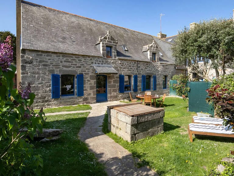 Maison en pierre volets bleus jardin avec 2 transats et un puits